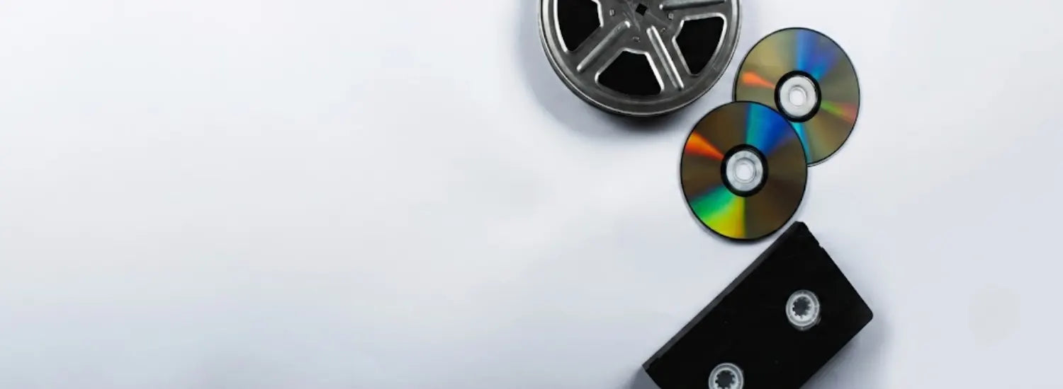 Several CDs, a VHS tape, and a film reel on a white background.